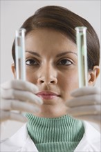 Indian female scientist looking at vials.