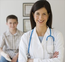 Female doctor with boy in background.