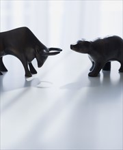 Bear and bull figurines facing each other.
