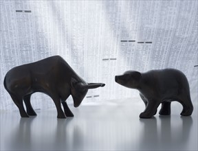 Bear and bull figurines facing each other.
