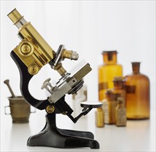 Old fashioned microscope and bottles.
