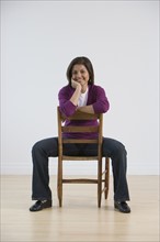 Indian woman sitting in chair backwards.