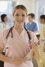 Portrait of female doctor holding medical chart.