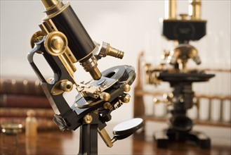 Old fashioned microscopes on table.