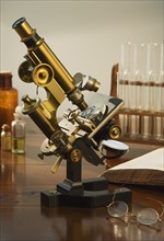 Old fashioned microscope on table.