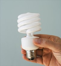 Man holding energy efficient light bulb.