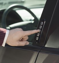 Man unlocking car door with keypad.
