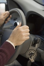 Man’s hands on steering wheel.