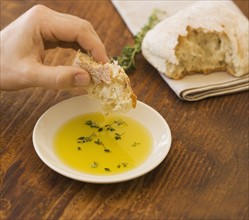 Man dipping bread in olive oil.
