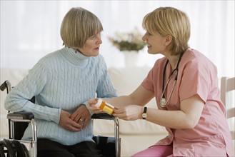 Nurse discussing medication with senior woman.