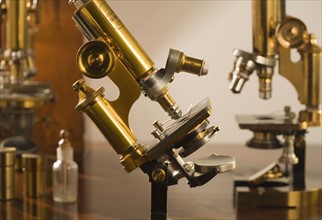 Old fashioned microscopes on table.