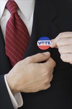 Businessman wearing Vote pin on lapel.