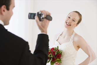 Groom video recording bride.