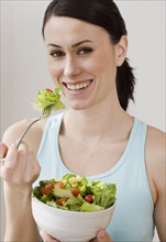 Portrait of woman eating salad.