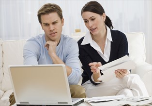 Couple paying bills on laptop.