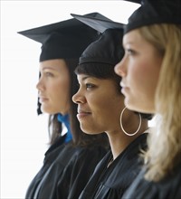 Multi-ethnic women wearing graduation cap and gown.