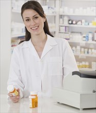 Portrait of female pharmacist holding medication.