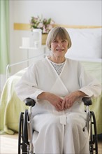 Senior woman sitting in wheelchair at hospital.