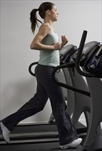 Woman running on treadmill at health club.