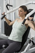 Woman exercising on machine at health club.