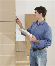 Man looking at stack of boxes.