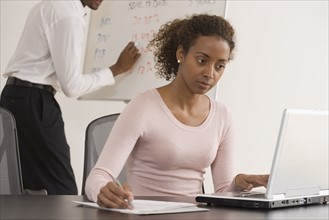 Businesswoman typing on laptop.