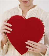 Woman holding heart shaped box.