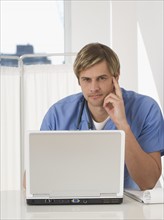 Portrait of male doctor with laptop.