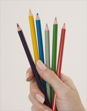 Close up of woman holding colored pencils.