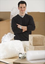 Portrait of man next to packing supplies.