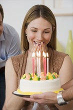 Woman smiling at birthday cake.