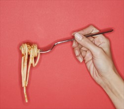 Woman holding forkful of pasta.