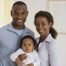 Portrait of parents holding baby.