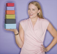 Woman holding stack of gift boxes.