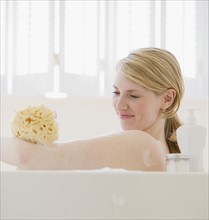 Woman washing in bathtub.