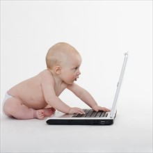 Baby looking at laptop.