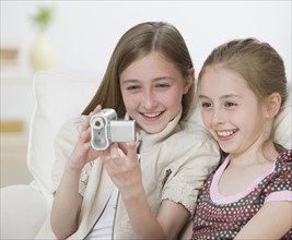 Two sisters looking video camera.