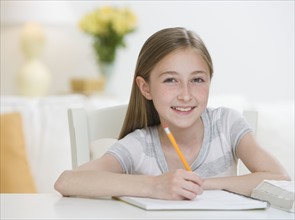Girl doing homework at table.