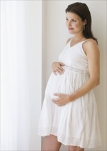 Pregnant woman with hands on belly.