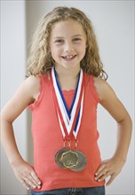 Girl wearing medals around neck.