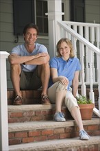Couple sitting on porch steps.