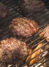 Hamburgers cooking on grill.