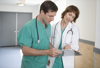 Female and male doctors discussing chart.