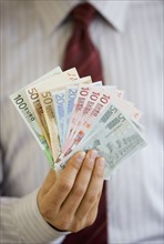 Businessman holding Euro banknotes.