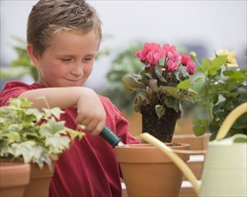 Boy watering potted plants.