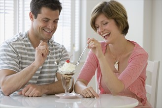 Couple sharing ice cream sundae.