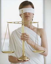 Blindfolded woman holding scales.