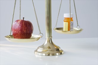 Apple and medication on scales.