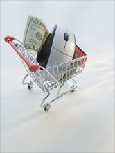Computer mouse and money in shopping cart.
