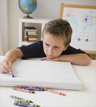 Boy coloring at table.